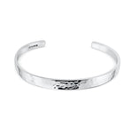 Silver bangle with a hammered design on a white background