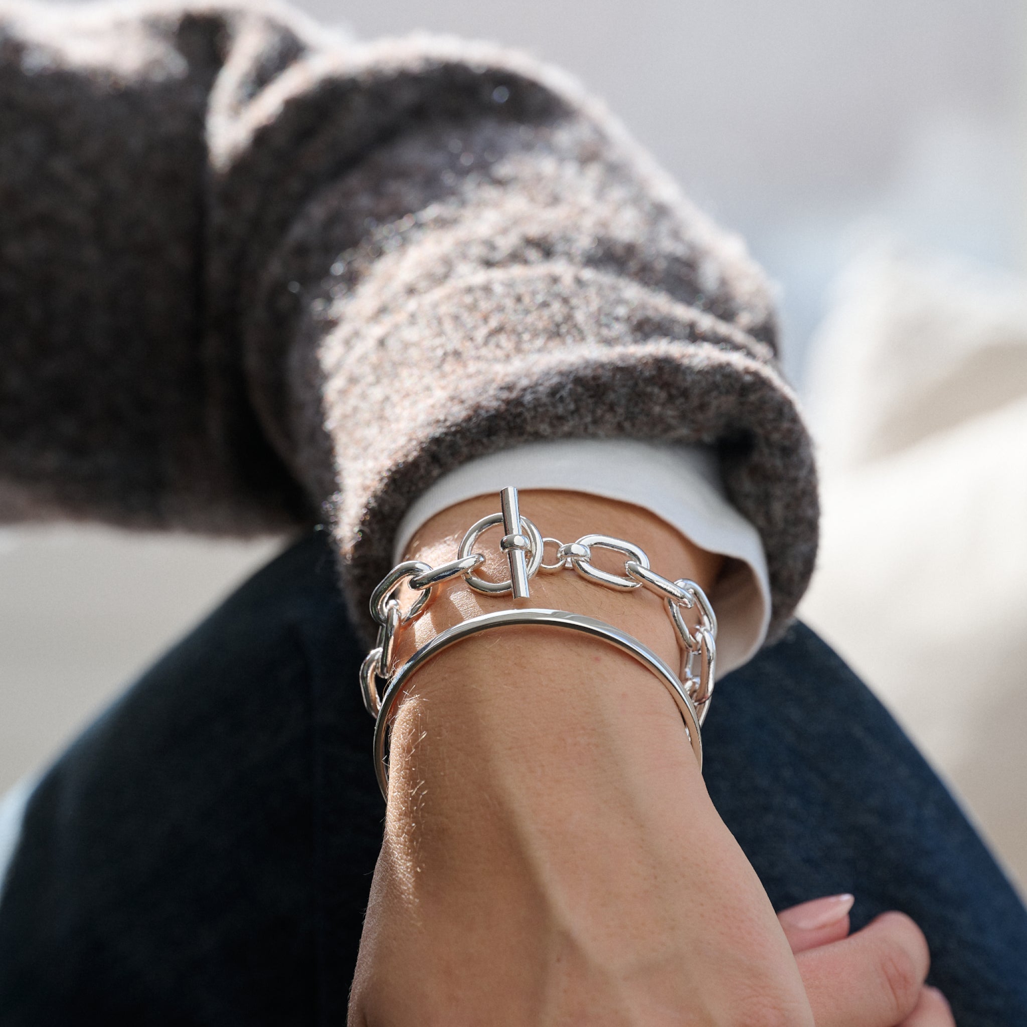 Silver chain bracelet on a wrist with a blurred background
