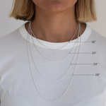 Woman wearing four different length necklaces with measurements indicated on a plain background