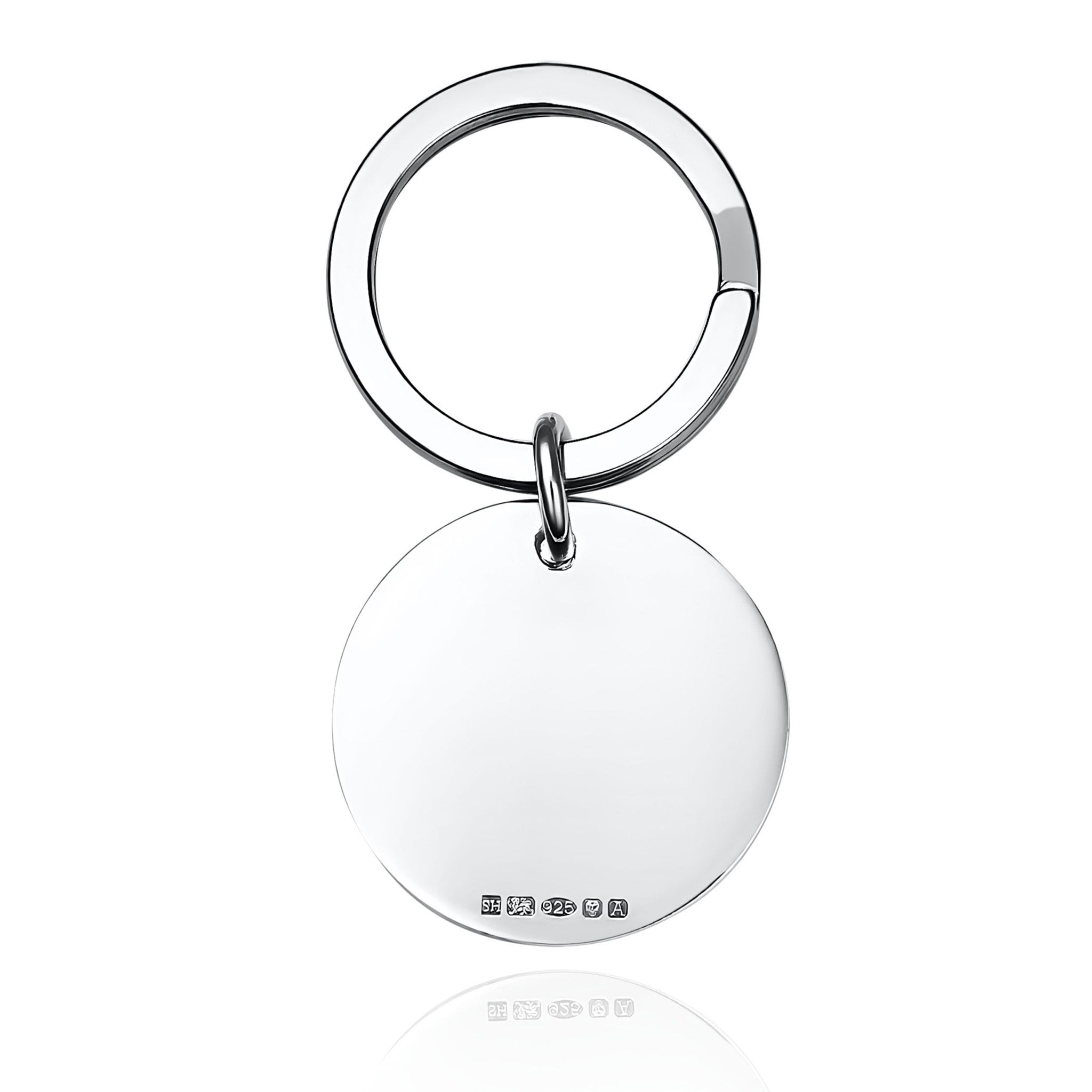 Round silver keyring with hallmarks on a white background