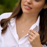 Woman wearing a necklace with a cross pendant outdoors