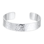 Silver cuff bracelet with a hammered texture on a white background