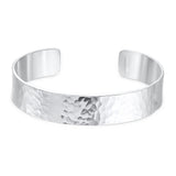 Silver cuff bracelet with a hammered texture on a white background