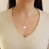 Necklace with a pendant worn by a person in a beige sweater