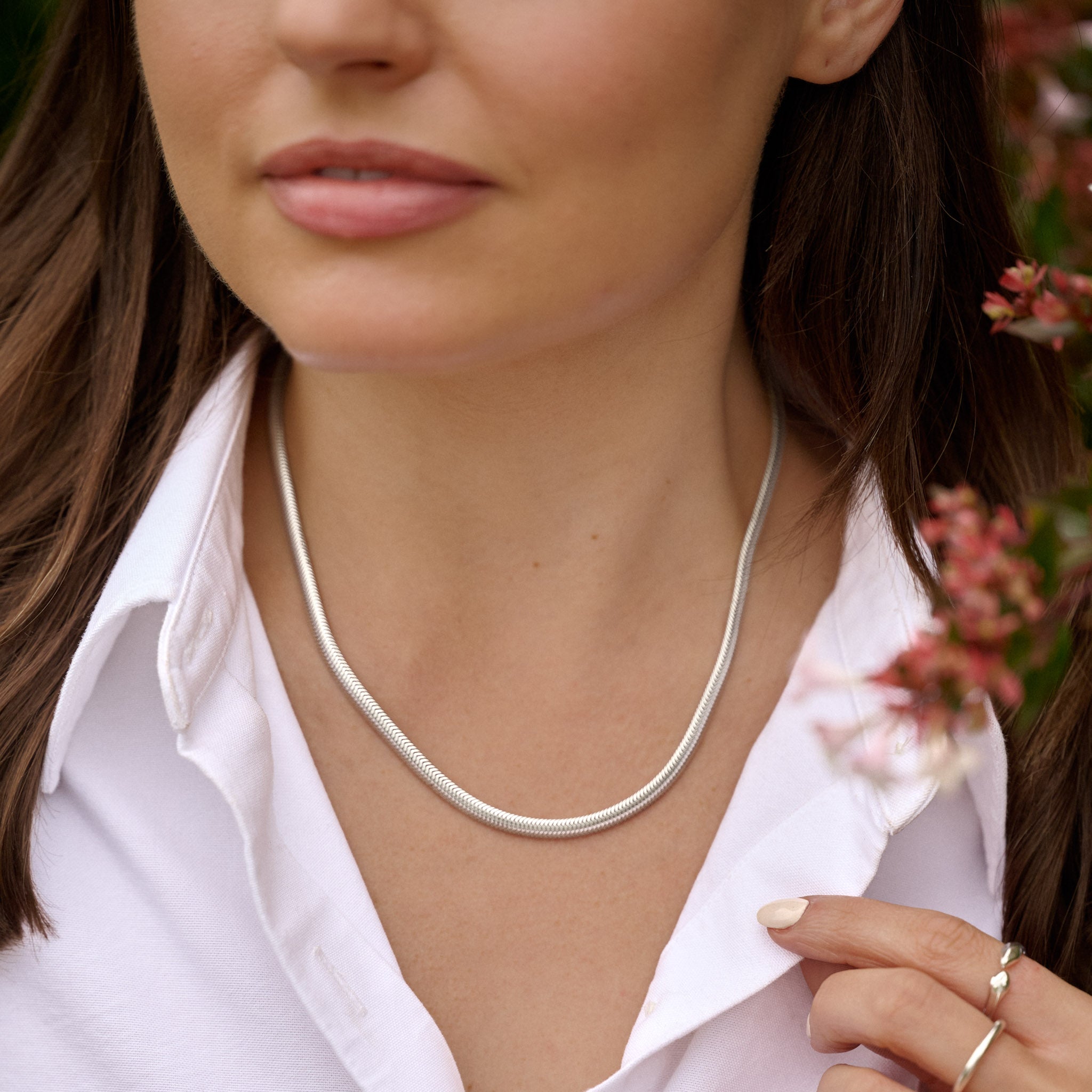 Woman wearing a silver necklace with a blurred background