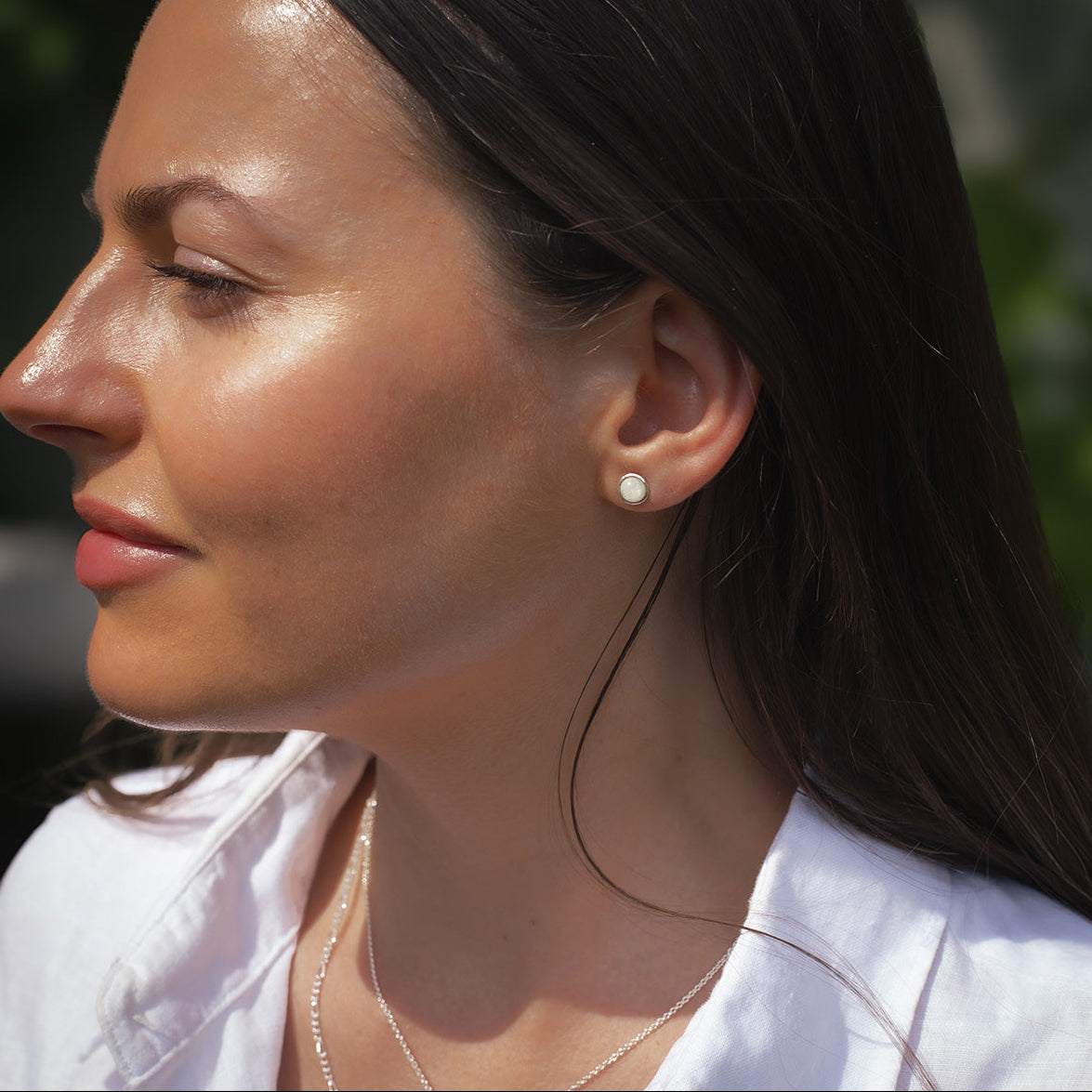 Close-up of a woman wearing a birthstone earring outdoors