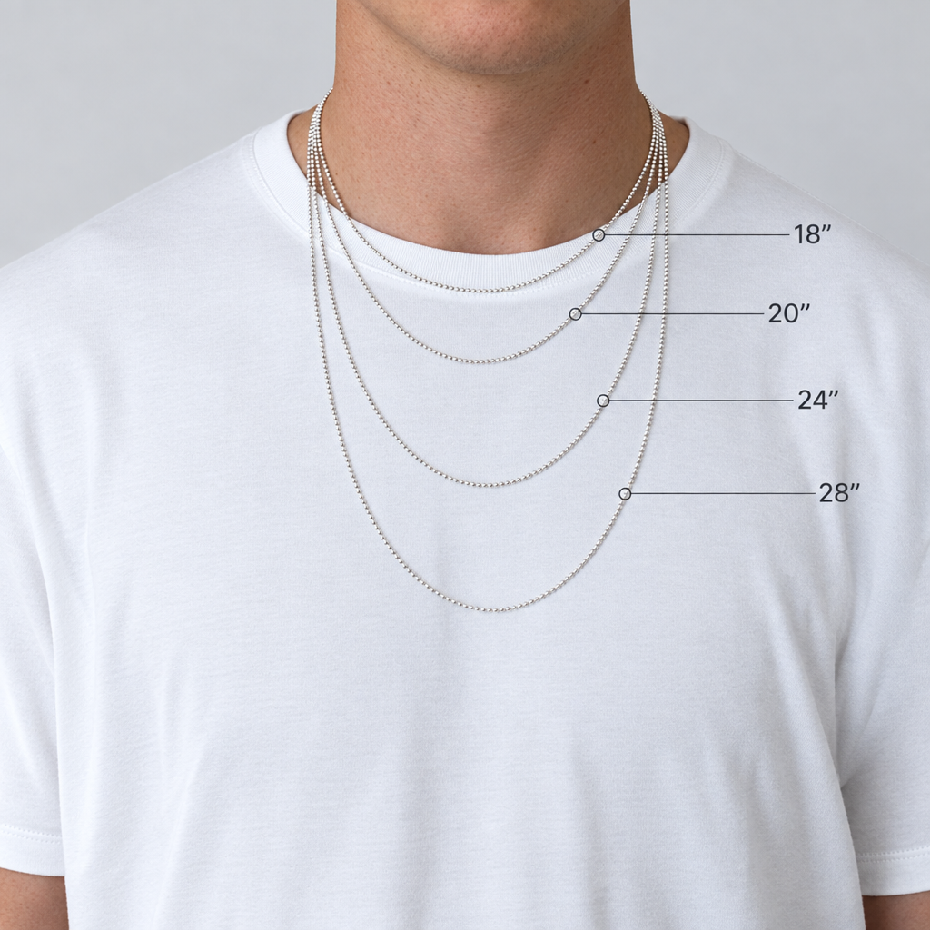 Man wearing four silver necklaces of different lengths on a plain background