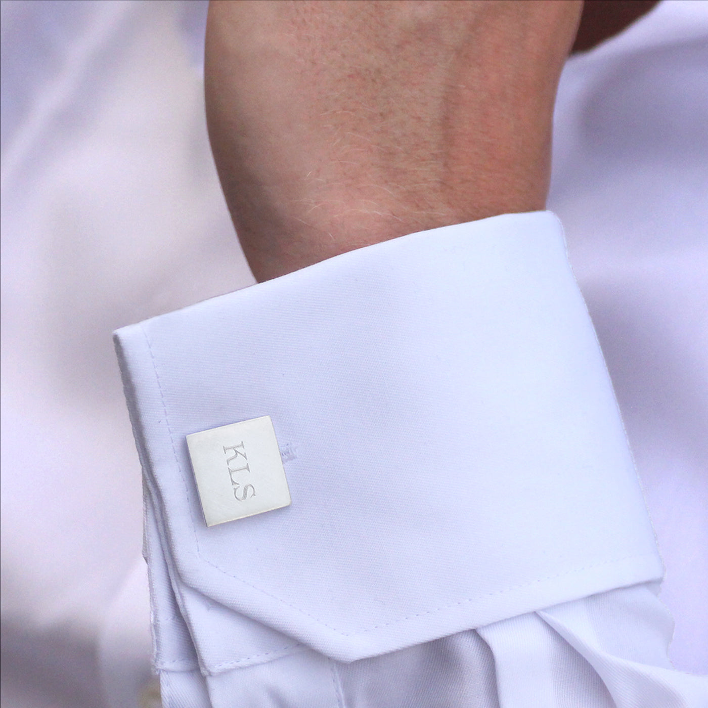 Close-up of a white shirt cuff with a visible brand label.