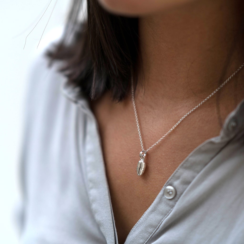 Silver coffee bean necklace on neck