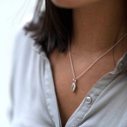 Silver coffee bean necklace on neck